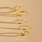 Five Mystery Rings with opal and diamond accents from our eclectic jewelry collection are displayed on a beige background with shadows.