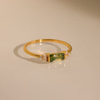 The Agate Baguette Ring showcases a rectangular green gemstone with sparkling diamonds on each side, all set in gold and photographed on a neutral background.