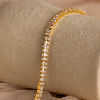 Detailed view of the Marquise Diamond Tennis Bracelet draped over a neutral textured surface, showcasing the brilliance of the marquise-cut stones.