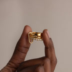 Hand holding the Multipurpose Mixed Metal Clasp Set featuring a unique dangling detail, perfect for stylish stacking, against a neutral background.