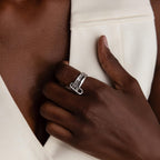 A hand with a Multipurpose Mixed Metal Clasp Set, ideal for stacking, rests on the chest against a white sleeveless garment.