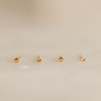 The Tiny Moon & Star Studs set includes two gold star studs and two crescent moon studs, creating a dreamy constellation-inspired look—perfect for lovers of dainty jewelry. Presented on a soft, neutral background.