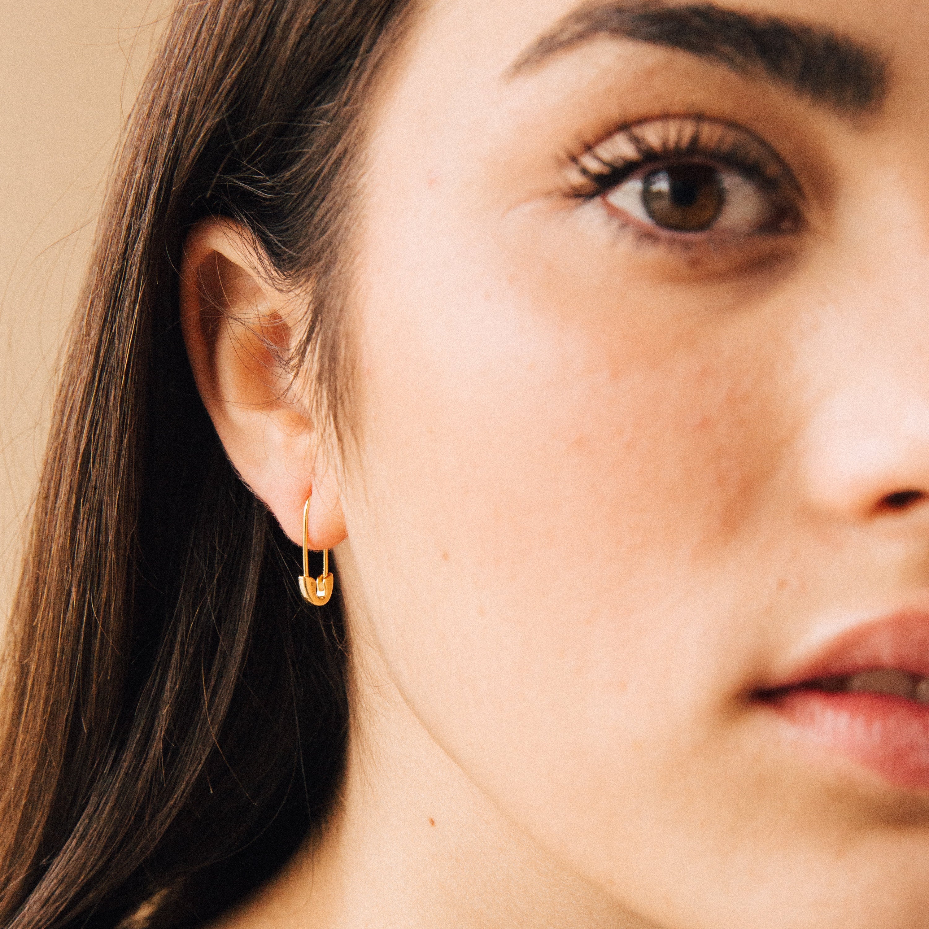 A close-up of a woman's face showcases her bold Safety Pin Earrings Set.