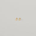 The Tiny Cross Studs are delicate stud earrings with small gold cross charms, shown against a plain white background.