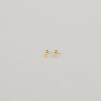 The Tiny Cross Studs are delicate stud earrings with small gold cross charms, shown against a plain white background.