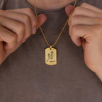 A person holds a Men's Dog Tag Necklace with a pendant featuring a childlike drawing and the words "I love you"—an ideal Father's Day gift.