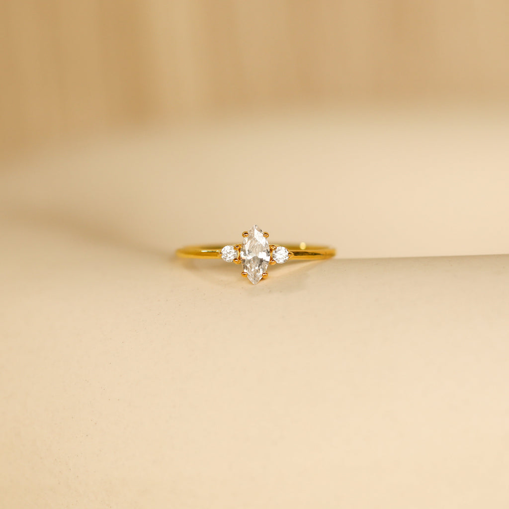 The Pave Marquise Birthstone Ring showcases a marquise-cut birthstone flanked by sparkling pave accents, all elegantly set on a sleek band.