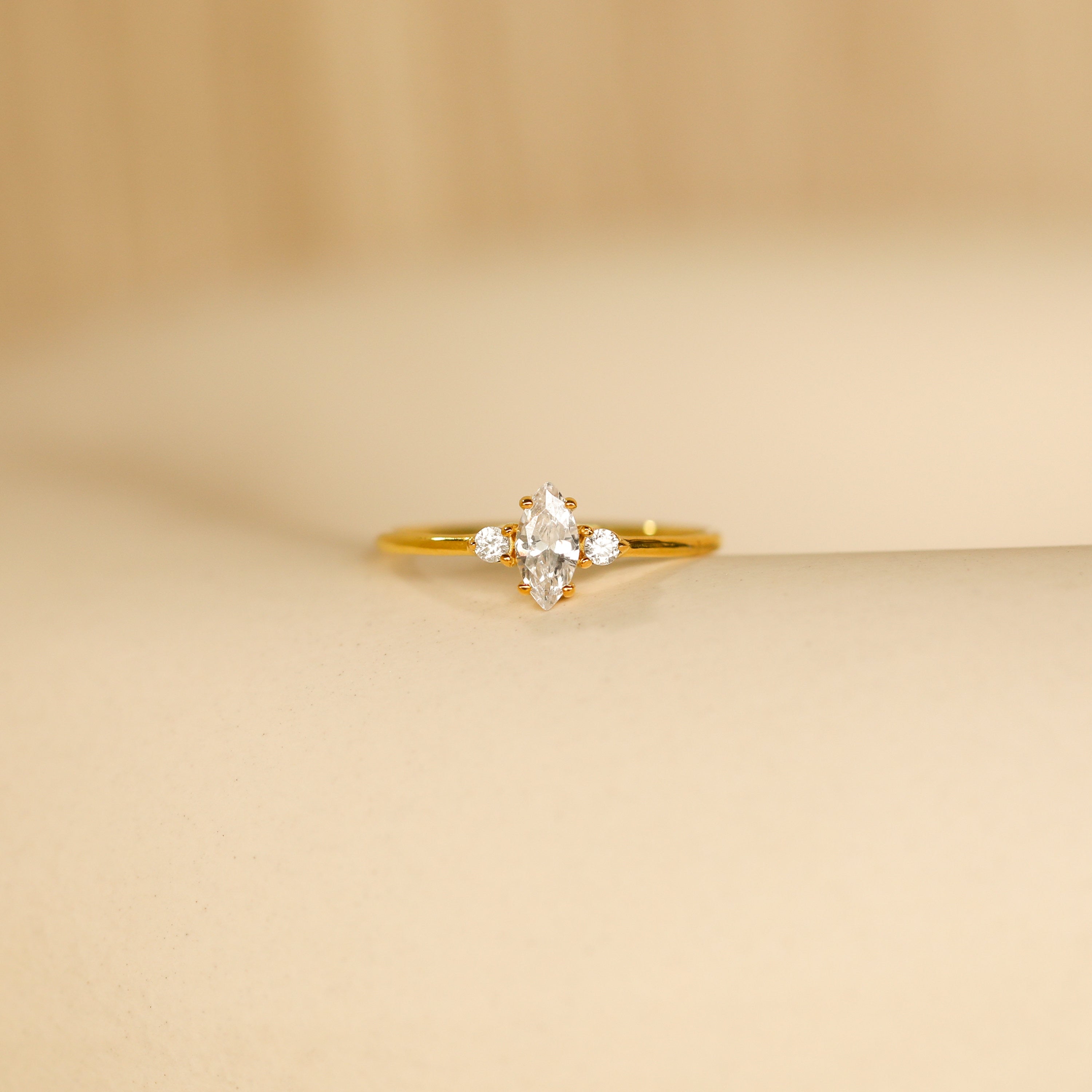 The Pave Marquise Birthstone Ring showcases a marquise-cut birthstone flanked by sparkling pave accents, all elegantly set on a sleek band.