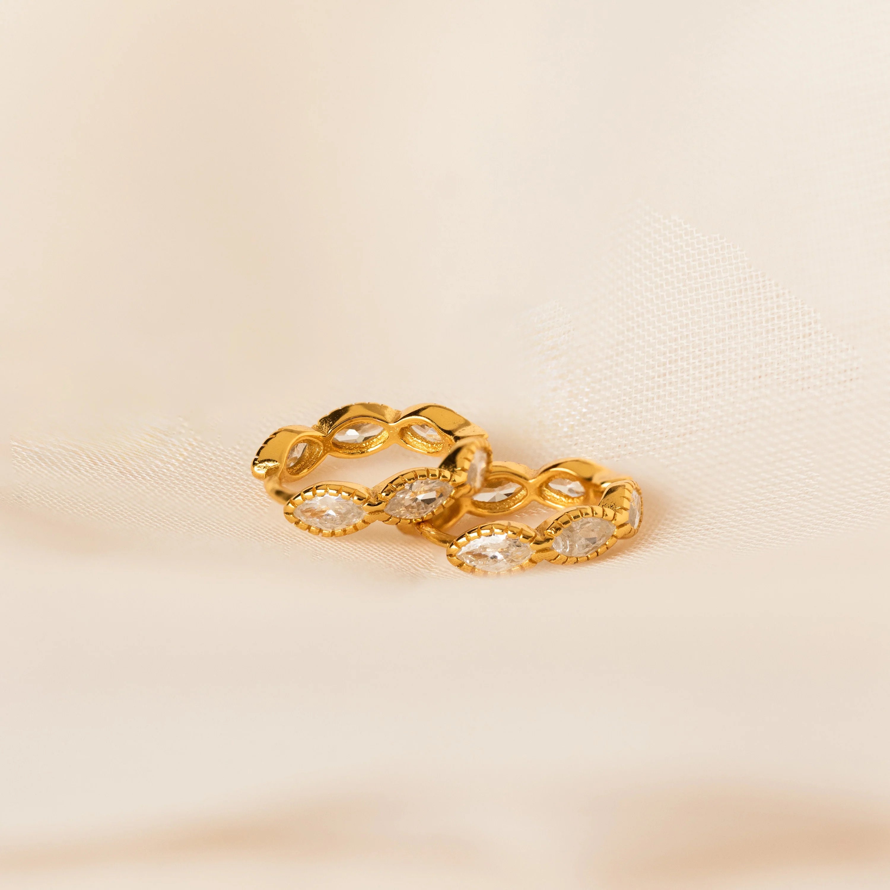 Diamond Butterfly Earrings Set, ideal for layering and adding sparkle, is showcased elegantly on a soft cream-colored fabric background.