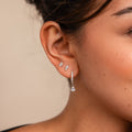 A close-up of a woman's ear adorned with the elegant Diamond Drop Earrings Set.