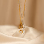 A Mother of Pearl Heart Charm in Sterling Silver necklace is displayed on smooth beige fabric, offering a touch of vintage-inspired elegance.