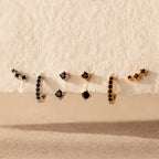The Black Diamond Earrings Set features bold huggie hoops and climber studs, each adorned with striking black stones for a captivating look.