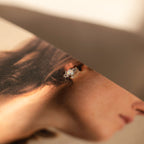 An Opal and Diamond Stud, ideal for cartilage or helix piercings, is displayed on a magazine image featuring a woman's ear and hair.