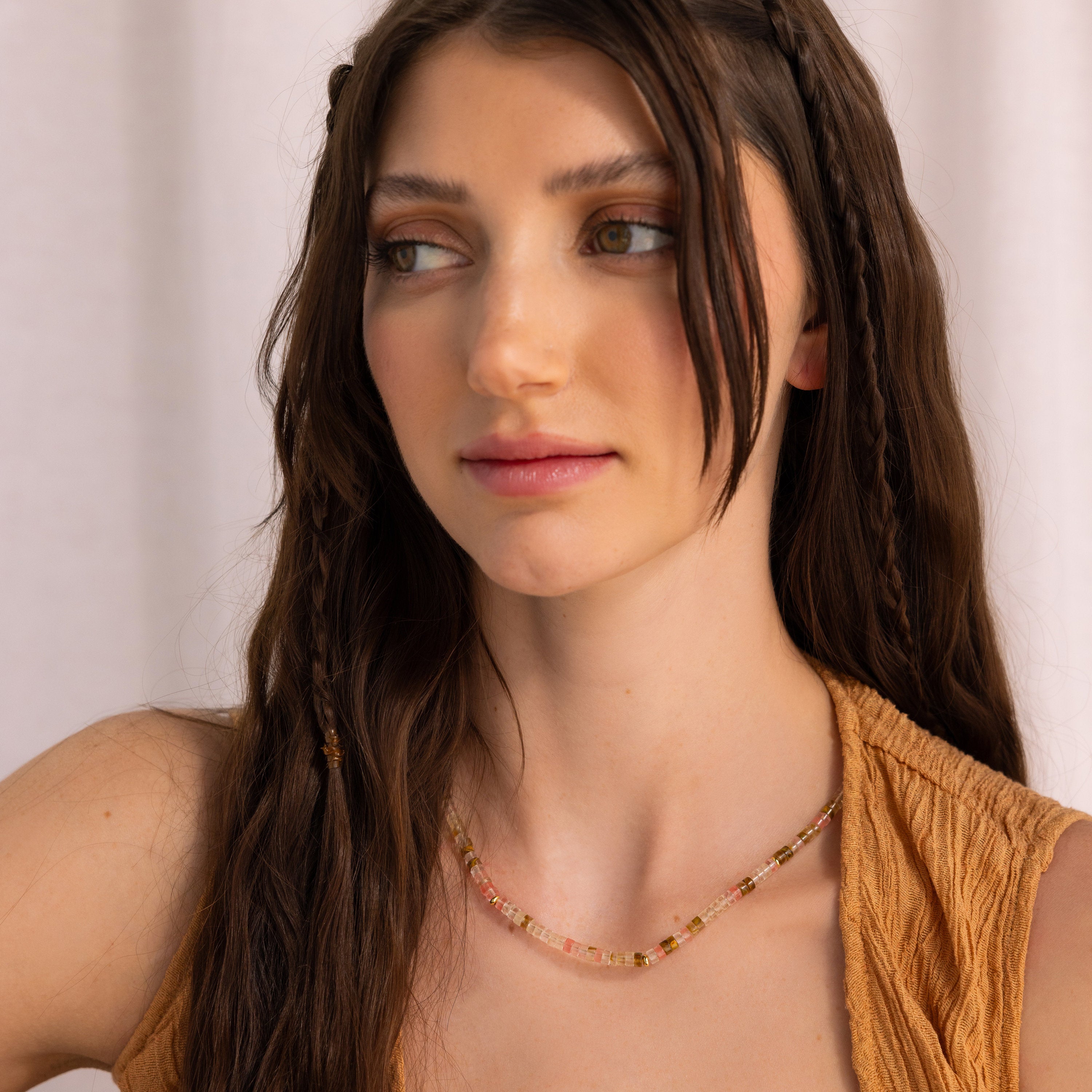 Brunette woman with braided hair wearing a sleeveless tan top and a Rose Quartz Beaded Necklace—an ideal gift for your best friend.