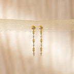 Dainty Diamond Drop Earrings with delicate bead details, ideal for bridesmaids, showcased against a soft beige fabric background.