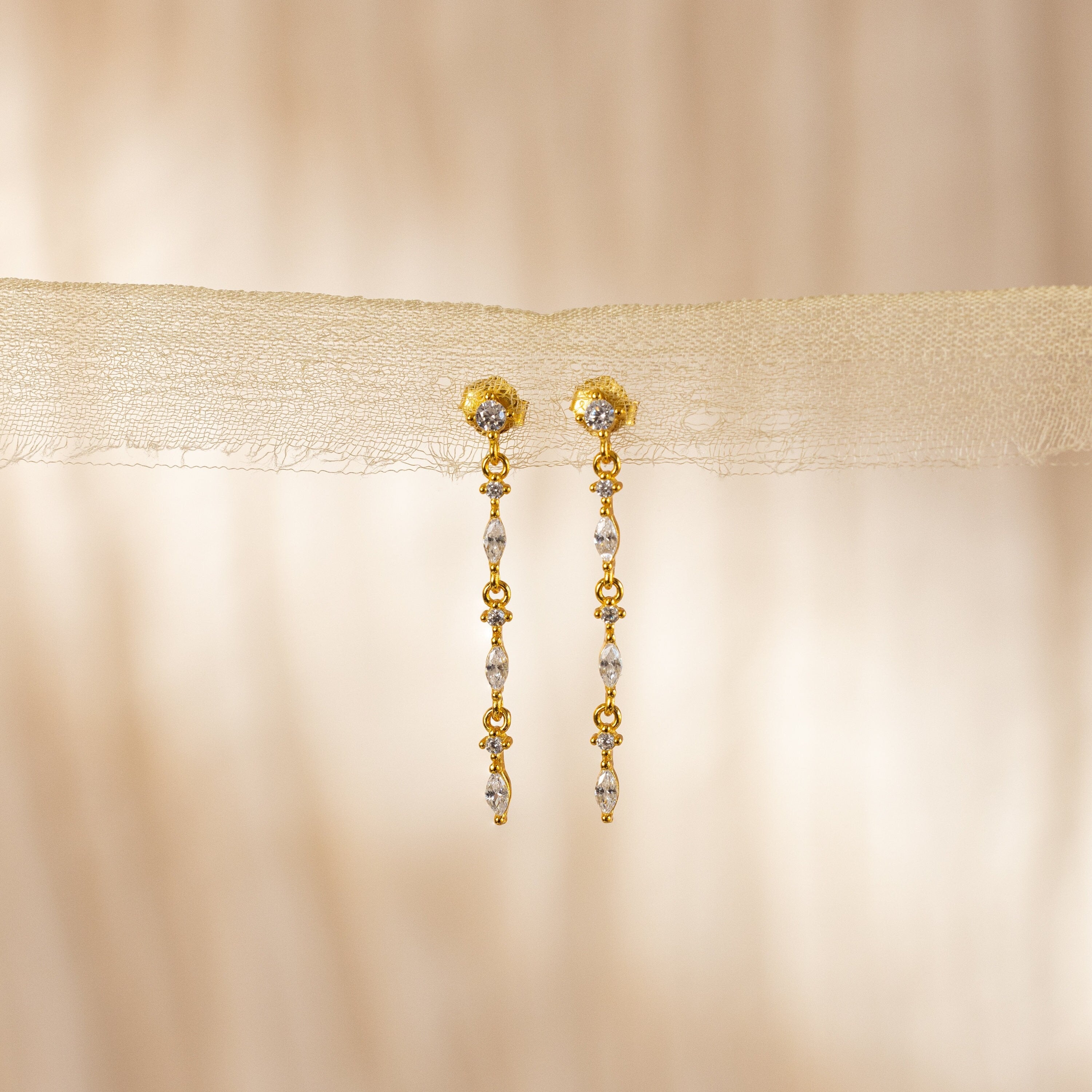 Dainty Diamond Drop Earrings with delicate bead details, ideal for bridesmaids, showcased against a soft beige fabric background.