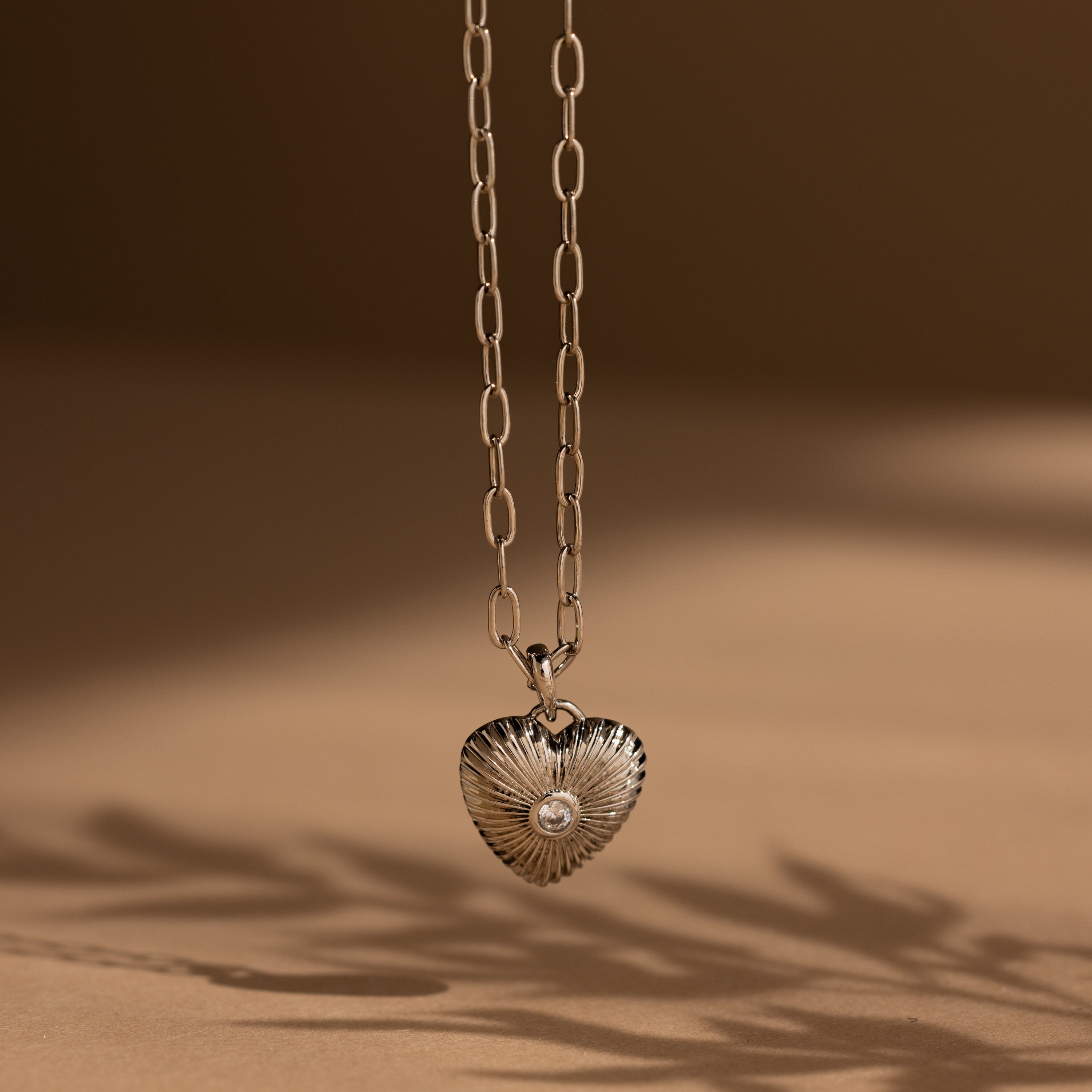 Diamond Ribbed Heart Necklace featuring a ribbed heart pendant with a central diamond, showcasing vintage-inspired elegance, displayed against a neutral background.