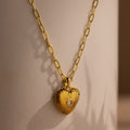 Diamond Ribbed Heart Necklace featuring a central gem on a gold chain, displayed against a neutral background—a stunning piece of vintage-inspired jewelry.