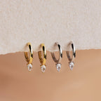 The Pear Diamond Drop Hoops set features two pairs of elegant hoops—one gold and one silver—each adorned with a clear teardrop-shaped gemstone, making them perfect for everyday elegance or as chic wedding accessories.