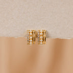 Diamond Pearl Stacked Hoops featuring rows of pearls and sparkling crystals, ideal for vintage wedding looks, showcased on a textured beige surface.