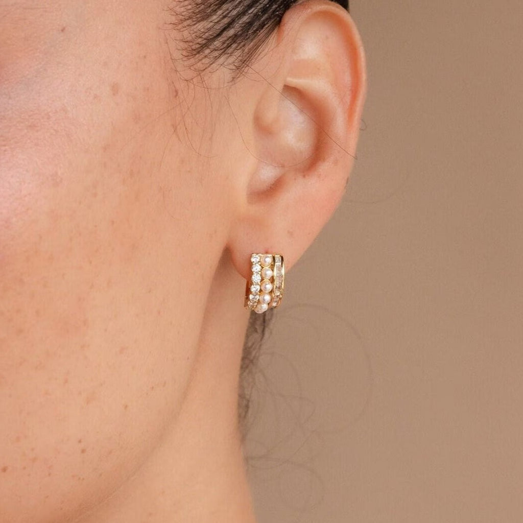 Close-up of a woman's ear wearing the Diamond Pearl Stacked Hoops—gold earrings featuring pearls and crystals, ideal as elegant bridal jewelry or vintage wedding earrings.