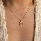The Pave Pearl Compass Necklace graces the neck, paired with a cream textured v-neck top for a subtle touch of nautical charm.