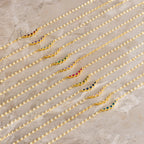 Nine Lace Birthstone Necklaces, each featuring a delicate gold chain and colorful gemstone, are arranged diagonally on a marble surface—perfect as dainty, personalized jewelry.