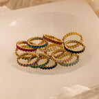 Eternity Marquise Birthstone Rings with colorful gemstones arranged in a circle on a white, translucent surface—each customizable for any birthstone, making it a thoughtful Christmas gift.