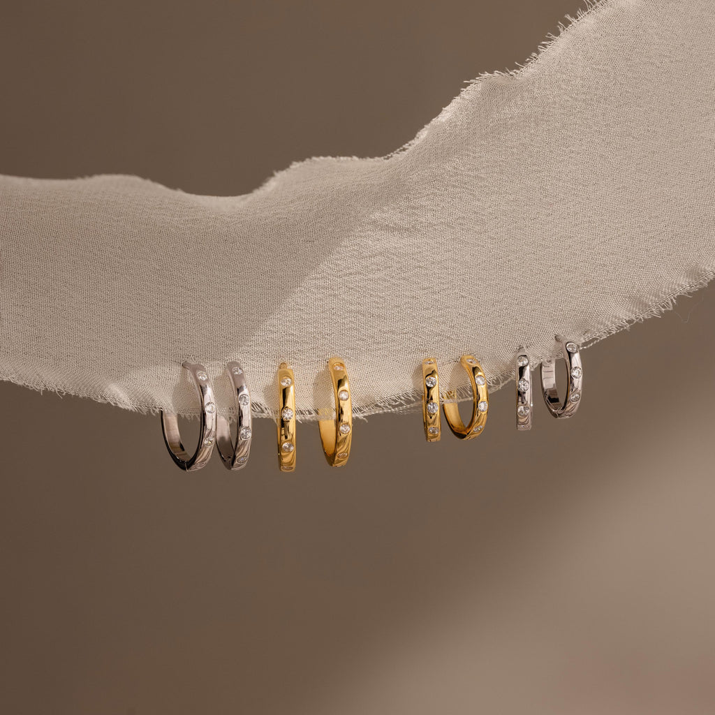 Classic Diamond Sprinkle Huggies pair beautifully with gold and silver rings, creating a timeless accessory collection.