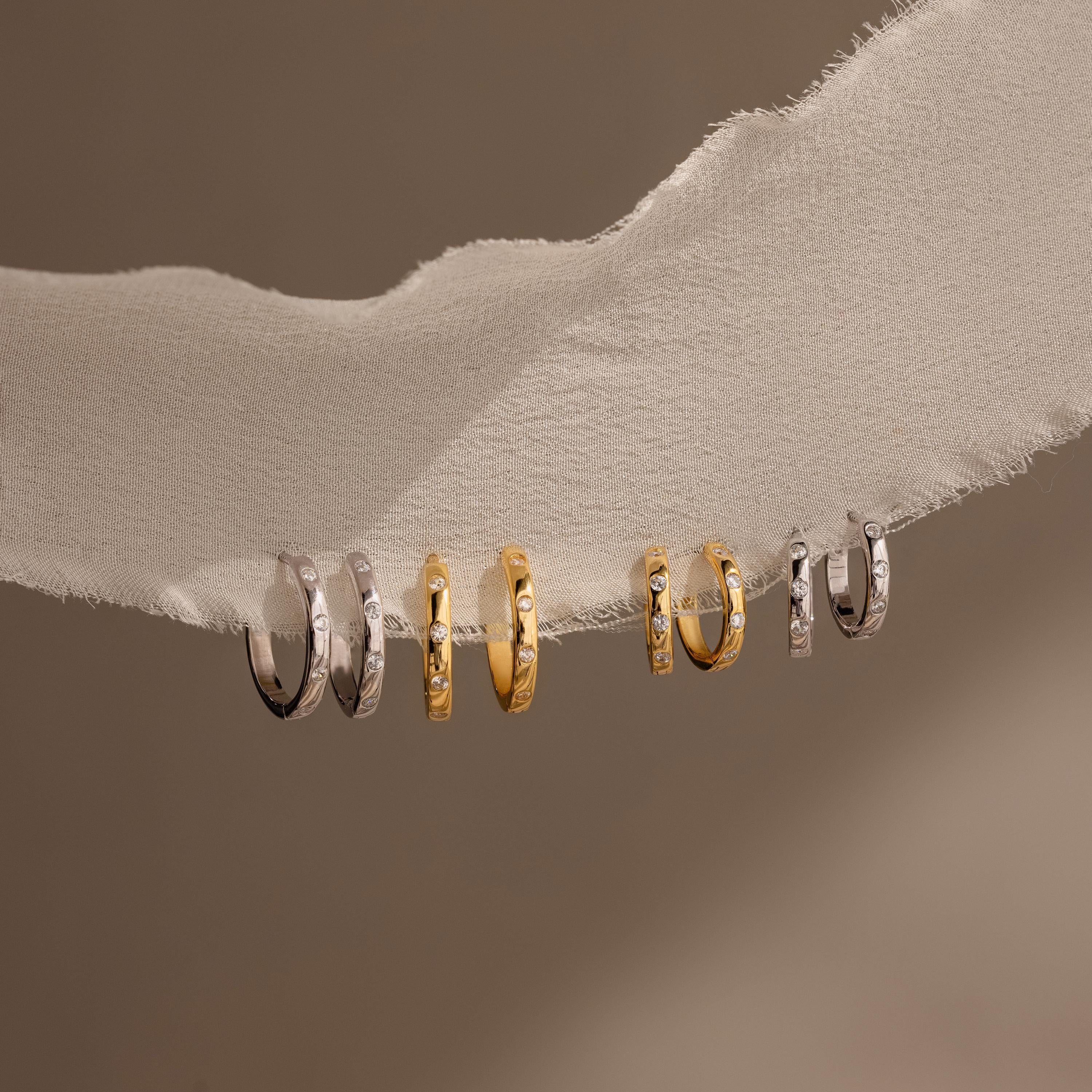 Classic Diamond Sprinkle Huggies pair beautifully with gold and silver rings, creating a timeless accessory collection.