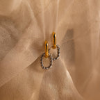 Mixed Metal Link Hoops, featuring gold and silver tones, are beautifully twisted and showcased on sheer beige fabric.
