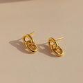 Link Drop Studs are shown on a beige surface with soft lighting, highlighting their elegant chain link design and casting delicate shadows.