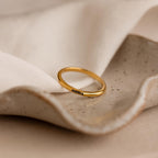 The Engraved Tiny Name Ring, personalized with “emma,” sits on a textured neutral ceramic dish—ideal for minimalistic jewelry lovers.