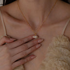 Model wears gold mirror chain with dangling Pave Evil Eye Charm