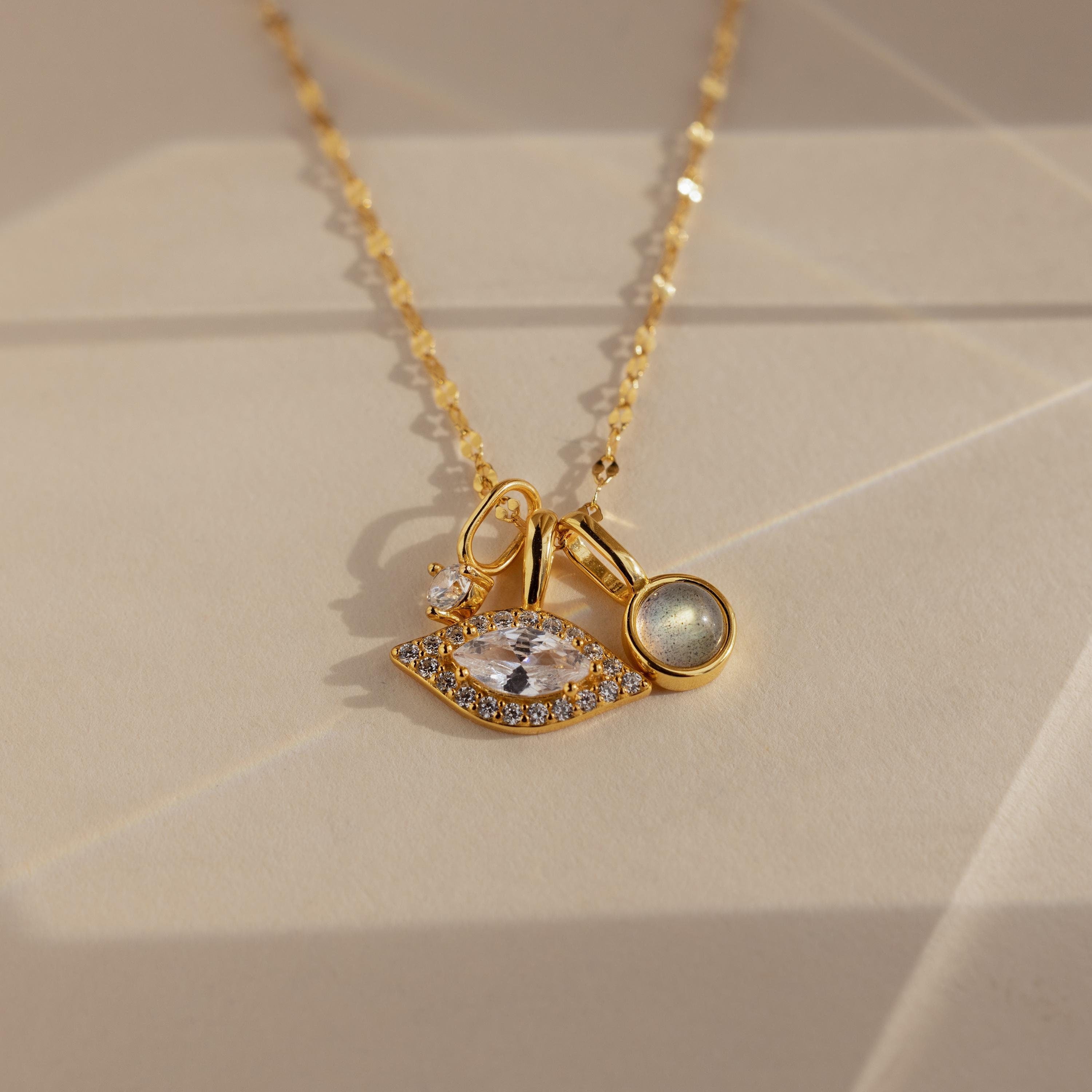 Gold Pave Evil Eye Charm on mirror chain, paired with a moonstone signet charm and diamond charm 