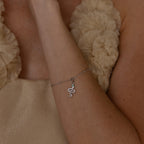 Model wears a silver diamond snake charm attached to a satellite bracelet