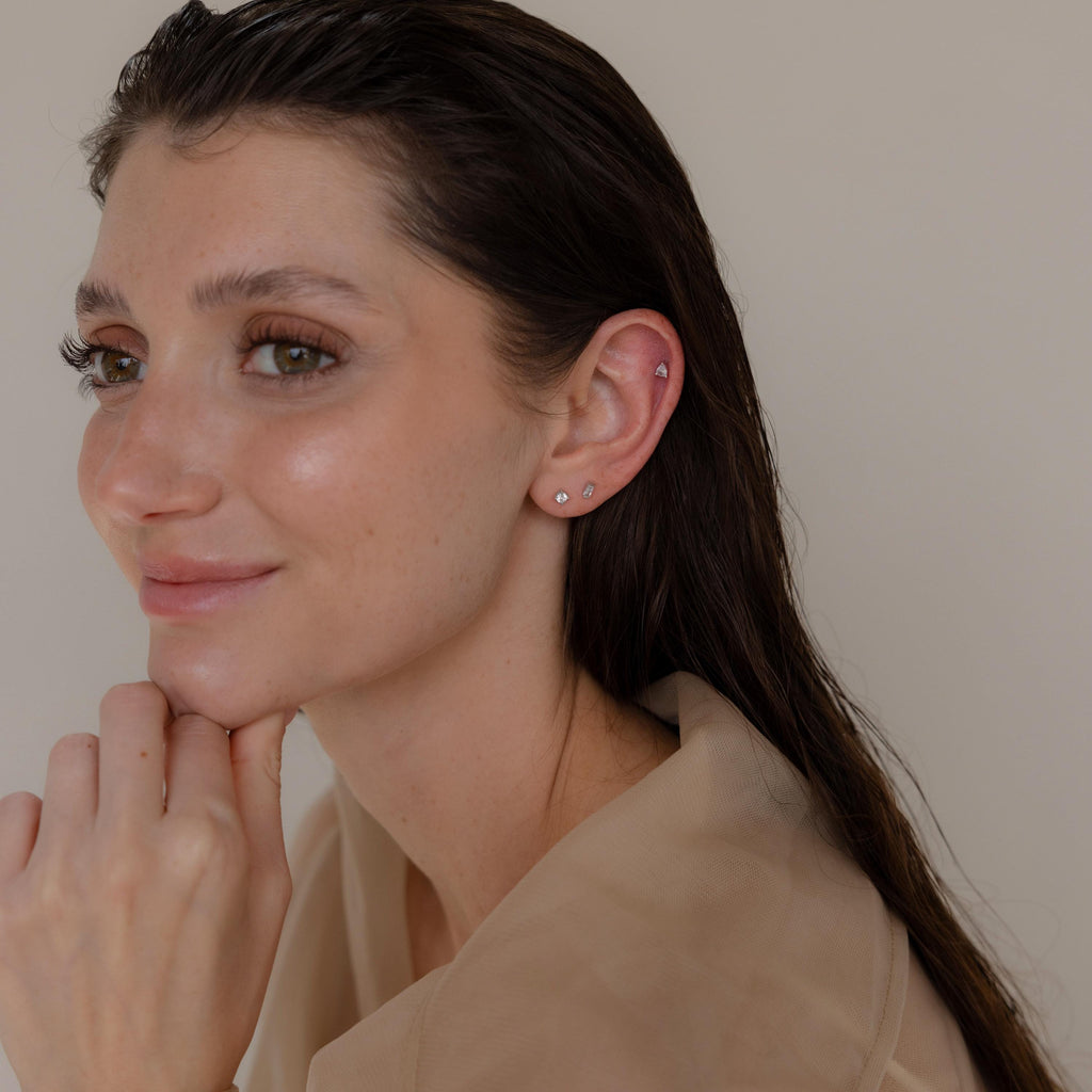 Woman with wet hair and neutral makeup, wearing a beige top and the Mixed Diamond Flat Back Stud Set, looks to the side with a slight smile.