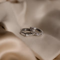 A pair of Diamond Ribbed Huggies sparkle with diamonds and a sleek ribbed design, displayed on smooth beige satin fabric.