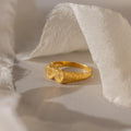 The Duo Initial Heart Ring features two heart shapes engraved with initials, beautifully displayed on soft, white fabric.