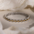 The Mixed Metal Link Bracelet in silver and gold is displayed on a soft, neutral background—an elegant and timeless gift for him.