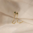 Agate Diamond Chain Earrings with green gemstones and gold chains, showcased on a soft beige fabric background.
