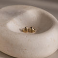 Checkered Heart Studs feature a retro black checkered pattern with a gold finish, beautifully displayed in a smooth, shallow stone dish.