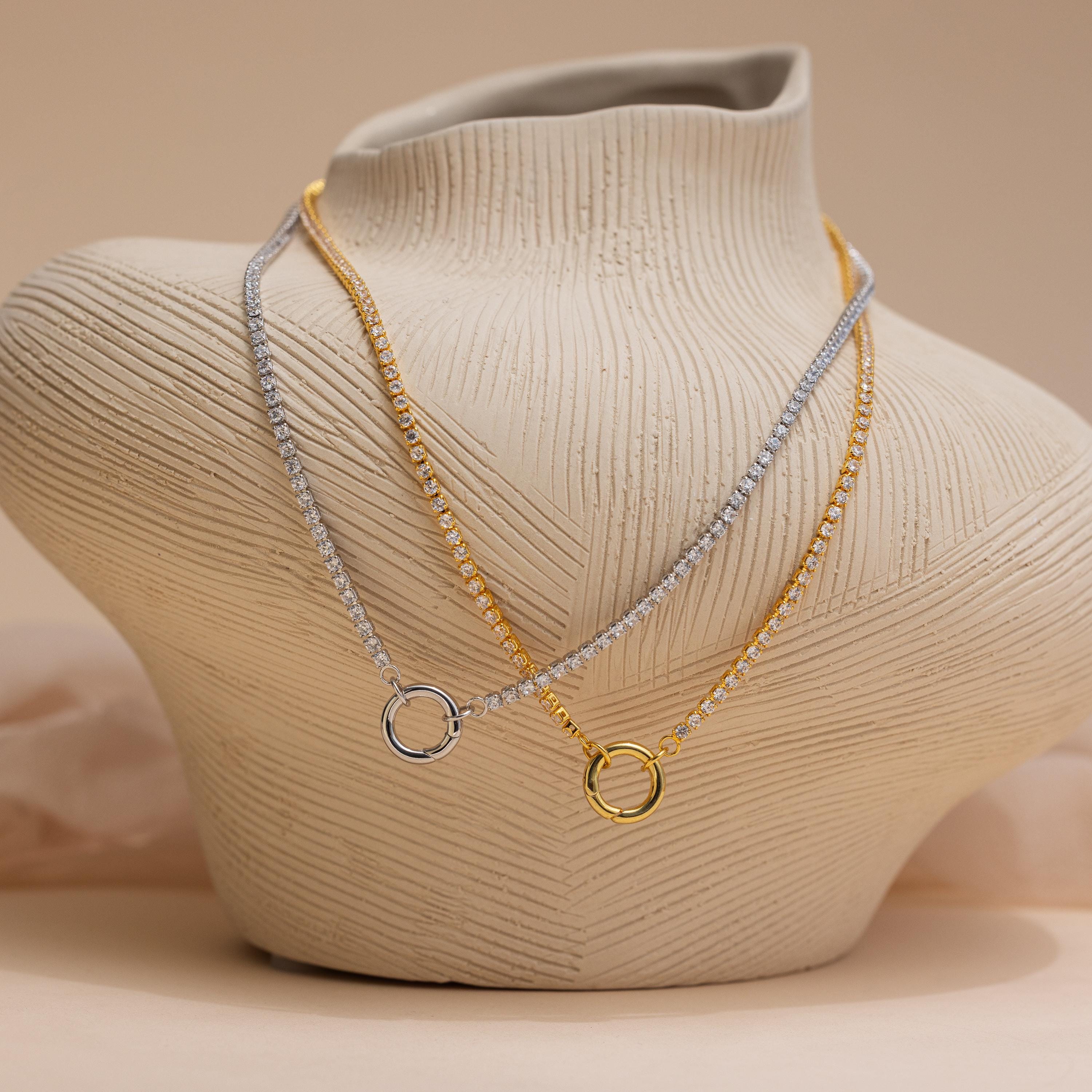 Two Diamond Tennis Clasp Necklaces—one in silver, one in gold—each with a round rolo clasp, displayed on a textured, neutral-toned bust. Timeless pieces perfect for wedding jewelry.