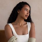 Woman with long curly hair wearing a white sleeveless top and the Diamond Tennis Clasp Necklace, featuring a rolo clasp, looking to the side against a neutral background.