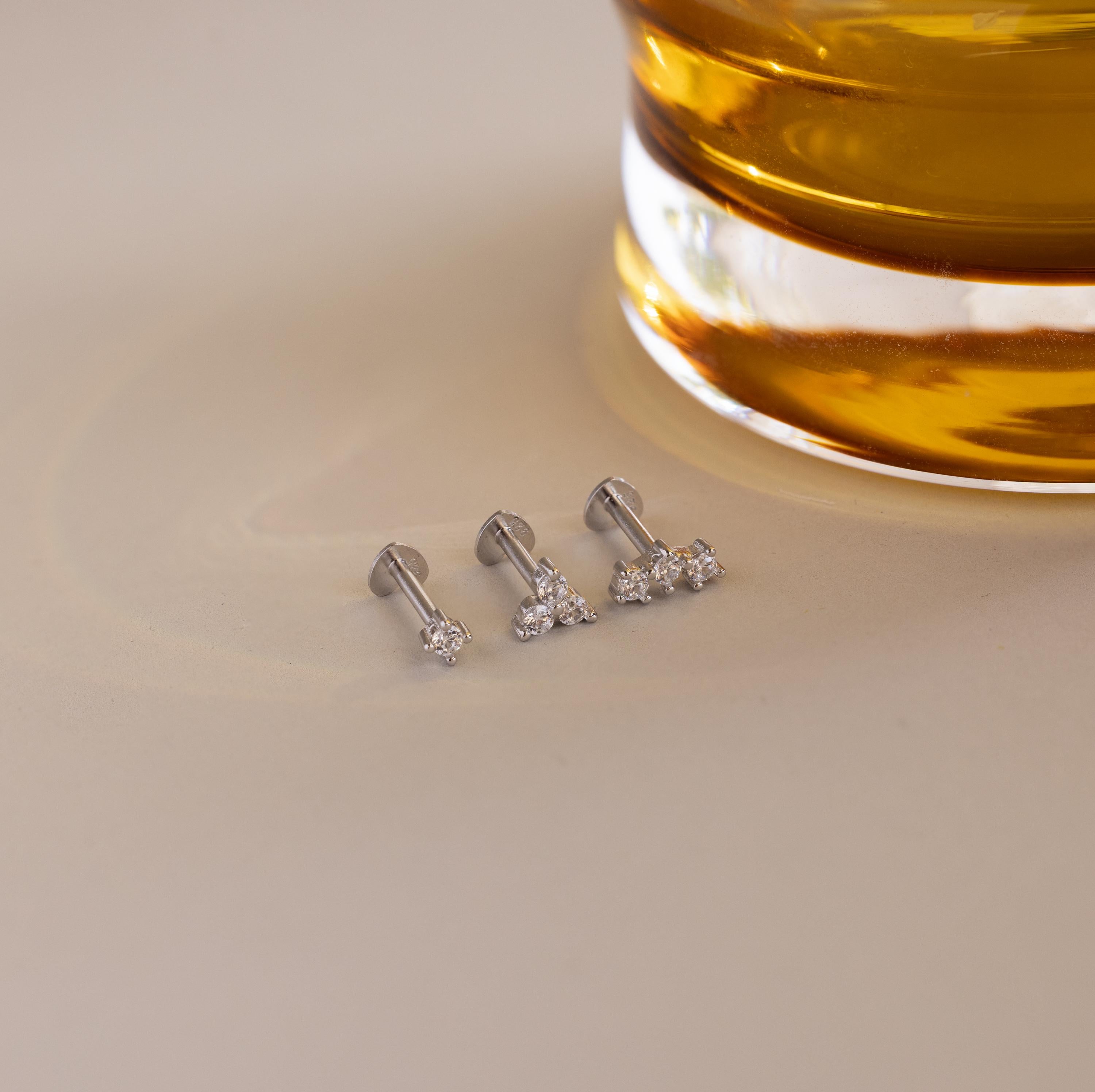 Flat lay of 3 silver CZ Diamond Constellation Studs with heart shaped flat backings