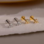 A lineup of four Opal Cluster Stud Earrings on a pale surface, showing two in silver and two in gold metal finish.