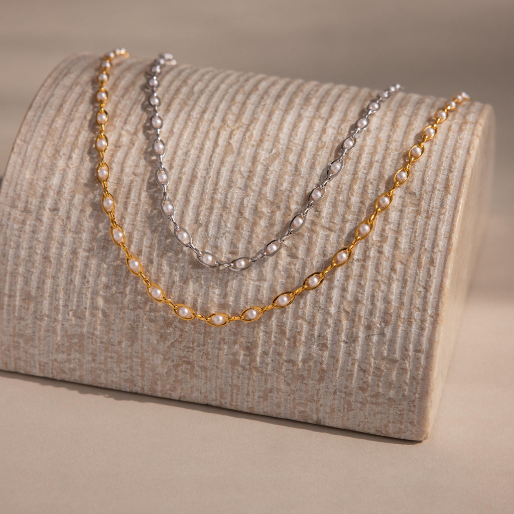 The Eternity Pearl Choker Necklace displayed on a textured beige stand, perfect for showcasing timeless beauty and ideal as elegant wedding jewelry.