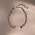 Beaded Pearl Bracelet in silver featuring faceted metallic beads with a single natural white pearl centerpiece, displayed on a neutral background for a sleek, modern look.