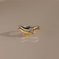 Stacked gold and silver curve rings with marquise cut stones, designed in a wavy silhouette for an elegant and modern look.