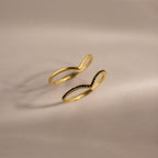Set of two gold curve rings, one with a smooth polished band and the other accented with black pavé stones, displayed on a neutral background.
